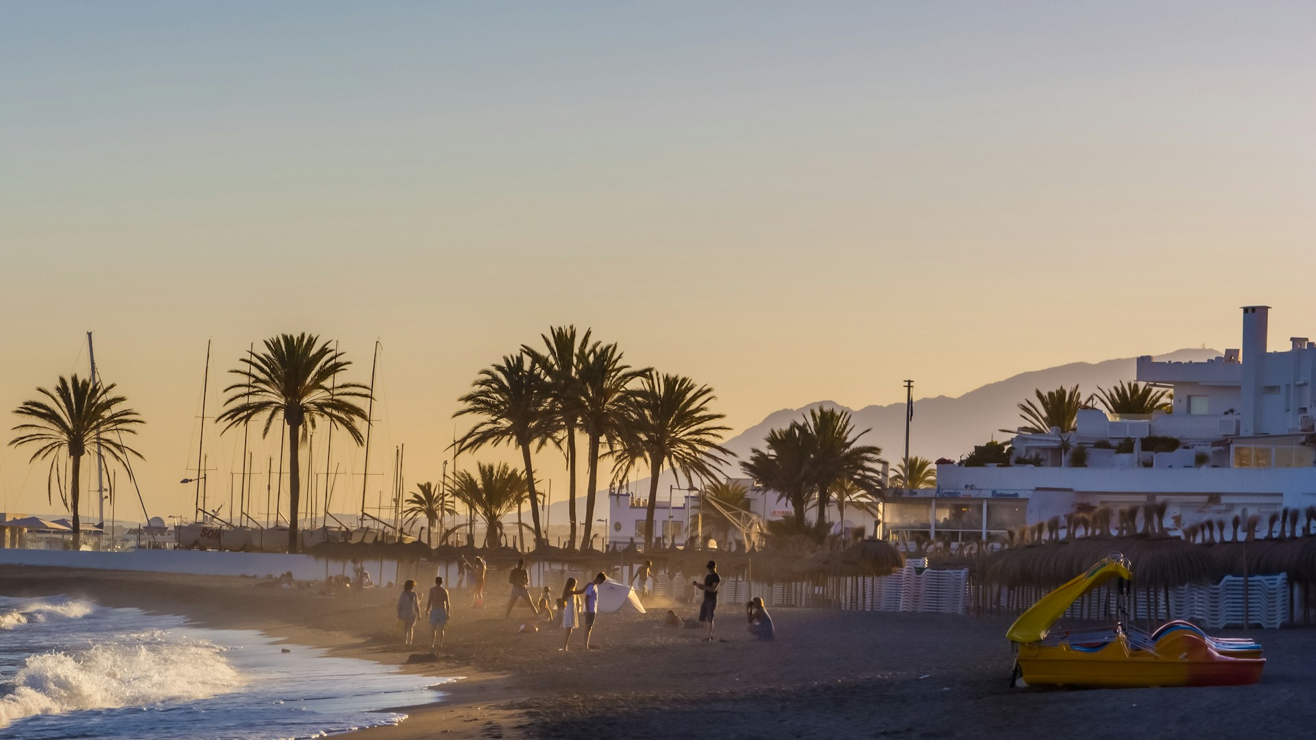 Folk på stranden i Marbella ved solnedgang