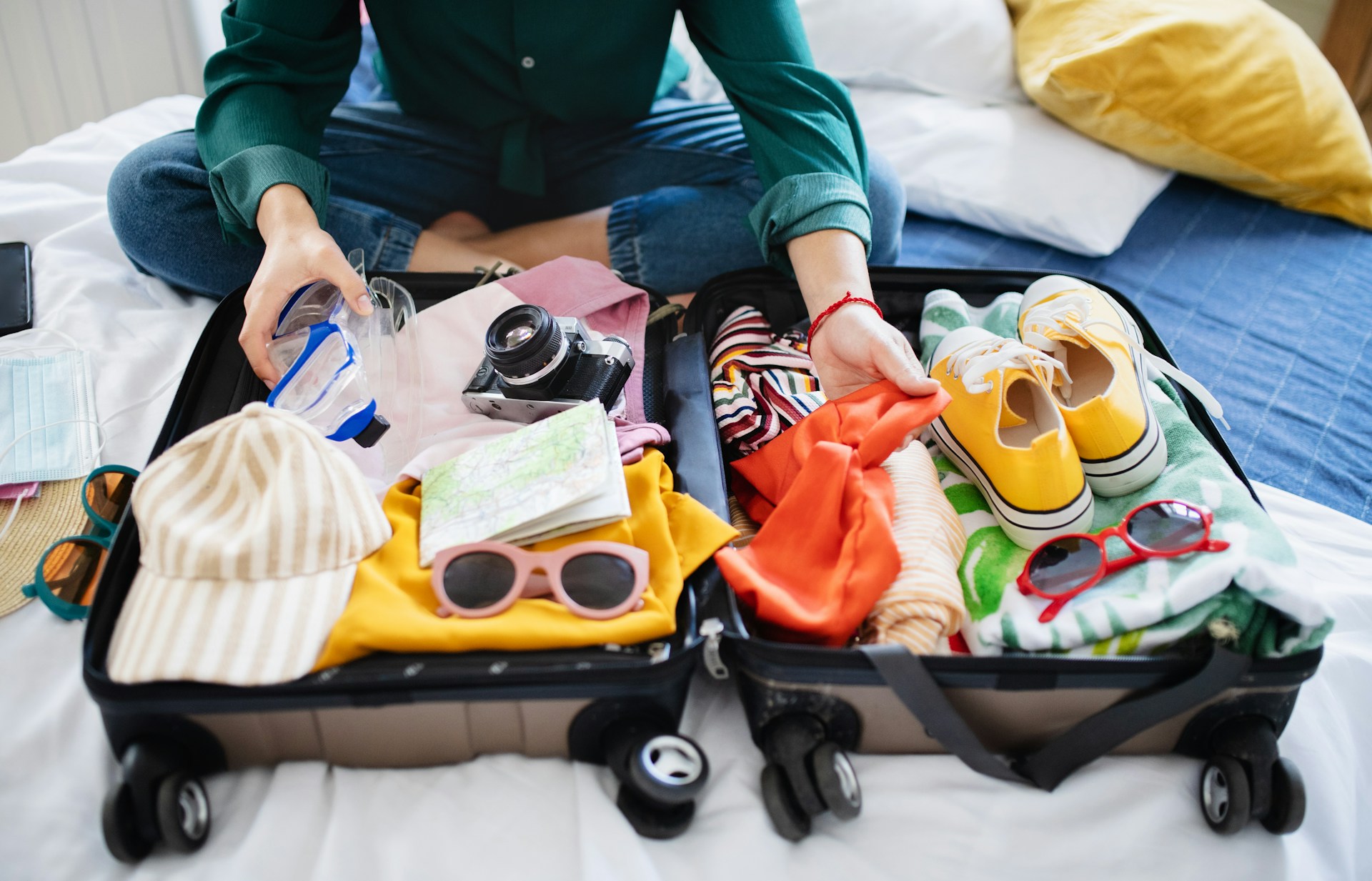 Tips for å pakke til et cruise: dette må du ha med Person som pakker til reisen sin i en koffert